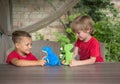 Two boys play at table with plush dinosaurs in role-playing games Royalty Free Stock Photo