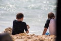 Two boys playful on vacation on the beach with sand on a hot summer day