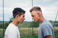 Two boys on playground looking at each other with hate.