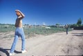 Two boys playing baseball on a dirt road, San Miguel, NM