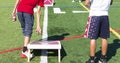 Two boys playing cornhole on a green turf field Royalty Free Stock Photo