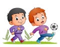 The two boys are playing the football and kicking the ball in the field Royalty Free Stock Photo