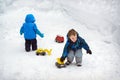 Two Boys Playing in Snow with Trucks Royalty Free Stock Photo