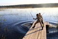 Two boys playing on wooden bridge by lake Royalty Free Stock Photo