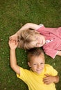 two boys of preschool age - tired of active games, lie on their backs on the grass, rest together