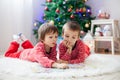 Two boys, reading a book in front of Christmas tree Royalty Free Stock Photo