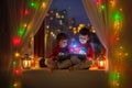 Two boys, reading book on the window