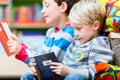 Two boys reading books in the library