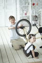 Two boys repairing bicycle indoors, Children mechanics, bike fixing