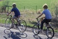 Two boys riding bicycles on rural road,