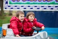 Two boys, riding boat in amusement park Royalty Free Stock Photo