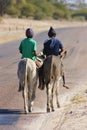 Two boys riding donkeys in Africa