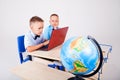 Two boys school computer desk globe Royalty Free Stock Photo