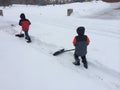 Two boys shoveling snow