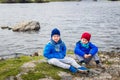 Two boys sit on the banks of the River in the spring Royalty Free Stock Photo