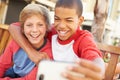 Two Boys Sitting On Bench In Mall Taking Selfie Royalty Free Stock Photo