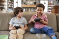 Two Boys Sitting On Sofa In Lounge Playing Video Game Together Royalty Free Stock Photo