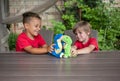 Two boys sitting at the table have fun playing role-playing games with plush dinosaurs Royalty Free Stock Photo