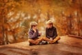 Two boys sitting by the water and talk. Royalty Free Stock Photo