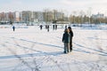 Two boys in skates stand on a frozen lake