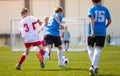 Two boys soccer teams competing for the ball during a football match