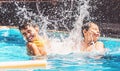 Two boys at the swimming pool splashing water and having fun. Royalty Free Stock Photo