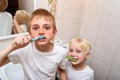 Two boys thoroughly brush their teeth in the bathroom. Morning hygiene