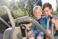 Two boys using digger on adventure playground in park