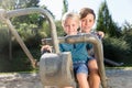 Two boys using digger on adventure playground in park Royalty Free Stock Photo