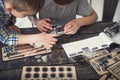 Two boys using various instruments while creating metal mechanism Royalty Free Stock Photo