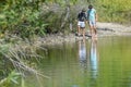 Two Boys Walking Along Shoreline of Beach