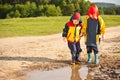 Two boys walking through a mud puddle