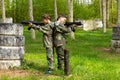 Two boys weared in camouflage playing laser tag in special forest playground Royalty Free Stock Photo