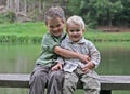 Two boys on wooden bench at the lake Royalty Free Stock Photo