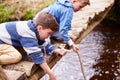Two Boys On Wooden Bridge Playing With Sticks In Stream Royalty Free Stock Photo