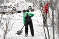 Two Boys Working Together Shoveling Driveway