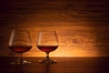 The two brandy glasses on a wooden background. Cognac on the table