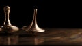 Two brass spinning top rotates on a copper plate on a black background. Time. Movie - Inception