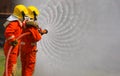 Two brave firefighter using extinguisher and water from hose for fire fighting, Firefighter spraying high pressure water to fire, Royalty Free Stock Photo