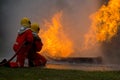 Two brave firefighter using extinguisher and water from hose for fire fighting, Firefighter spraying high pressure water to fire,