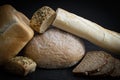 Two breads, half a French baguette and buns on the table. Royalty Free Stock Photo