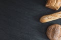 Two breads and one french baguette on a black background. Royalty Free Stock Photo