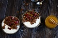 Two breakfast bowls with crunches, honey, berries and yogurt