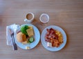 Two breakfast plates with eg bred, bacon and scrambled eggs, and coffee with milk and apple juice Royalty Free Stock Photo