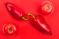 Two bright big red bell peppers and two red tomatoes on red background top view closeup Royalty Free Stock Photo