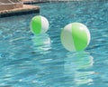 Close-up two bright green beach ball in swimming pool sunny day