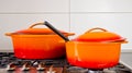 Two bright orange pots from cast iron with enamel at an old vintage gas stove Royalty Free Stock Photo