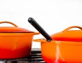 Two bright orange pots from cast iron with enamel at an old vintage gas stove Royalty Free Stock Photo