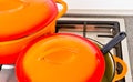 Two bright orange pots from cast iron with enamel at an old vintage gas stove Royalty Free Stock Photo