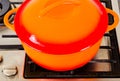 Two bright orange pots from cast iron with enamel at an old vintage gas stove Royalty Free Stock Photo
